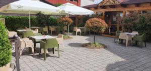 a patio area with tables, chairs and umbrellas at Noblesse Boutique Resort in Sibiu