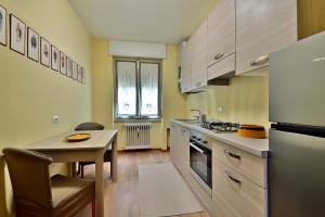eine Küche mit einem Tisch, einem Kühlschrank und einer Spüle in der Unterkunft CASA DEI LIMONI in Gardone Riviera