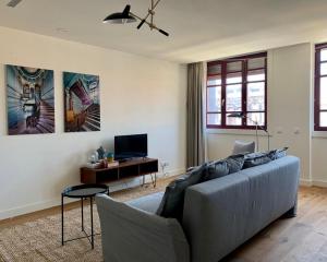 a living room with a couch and a tv at Oporto Chic&Cozy - Batalha II in Porto
