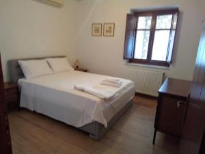 una camera da letto con un letto con due asciugamani sopra di Boliari house a Oitylo