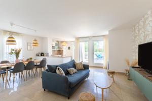 a living room with a blue couch and a table at Le Duplex - Disneyland - Rooftop - Wifi in Montévrain