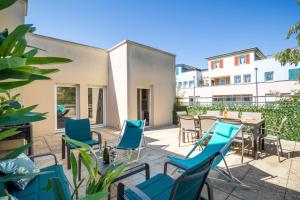 a patio with blue chairs and a table at Le Duplex - Disneyland - Rooftop - Wifi in Montévrain