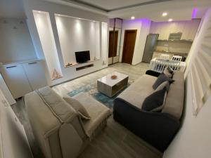 a living room with a couch and a tv at Studio apartman Holiday in Tivat