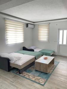 a bedroom with two beds and a coffee table at Studio apartman Holiday in Tivat