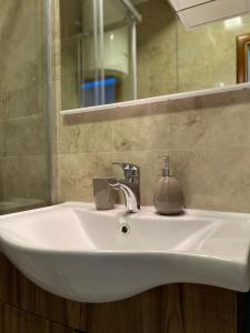 a white sink in a bathroom with a mirror at Studio apartman Holiday in Tivat +20 photos