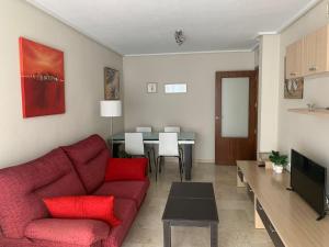 sala de estar con sofá rojo y mesa en Apartamento Classic OscVict en El Palmar, Murcia. en Murcia