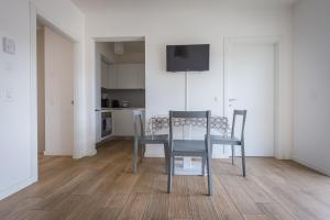 a dining room with a table and chairs and a kitchen at Modern apartment in Lugano in Lugano