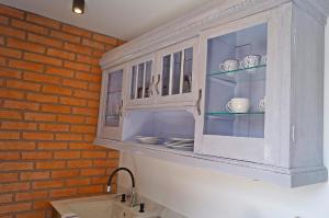a white cabinet with dishes in it in a kitchen at Apartament Pisz in Pisz