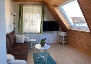 uma sala de estar com um sofá e uma televisão em Haus Josefine em Friedrichshafen
