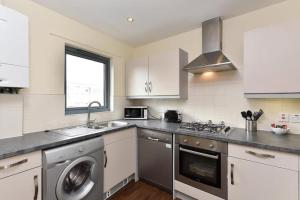 a kitchen with a washing machine and a sink at Bright 2 Bedroom Flat in Lambeth With Balcony in London