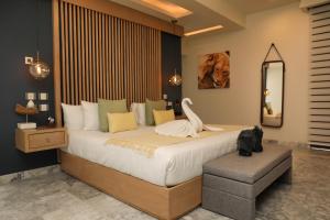 a hotel room with a bed, chair, and nightstand at Panther Bay Villa & Golf in Akumal