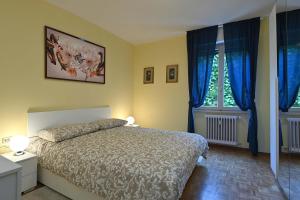 a bedroom with a bed and two windows with blue curtains at CASA DEI LIMONI in Gardone Riviera