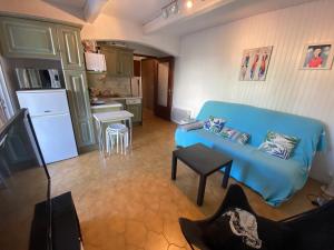 a living room with a blue couch and a kitchen at Boost Your Immo Six Fours Les Plages Le Marie Louise 485 in Six-Fours-les-Plages