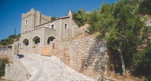 un muro di pietra con un edificio su una collina di Boliari house a Oitylo