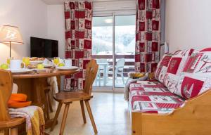ein Wohnzimmer mit Tisch und Couch und ein Esszimmer in der Unterkunft APPARTEMENT CALME 5 PERSONNEs CENTRE ST LARY PISCINE COUVERTE in Saint-Lary-Soulan