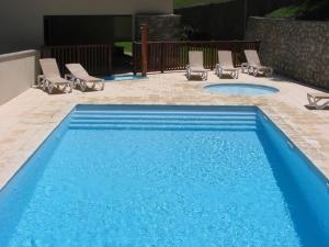 einen blauen Pool mit Liegestühlen in der Unterkunft APPARTEMENT CALME 5 PERSONNEs CENTRE ST LARY PISCINE COUVERTE in Saint-Lary-Soulan + 9 Fotos