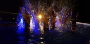 a group of people playing in a fountain at night at Vila Alunis in Buşteni