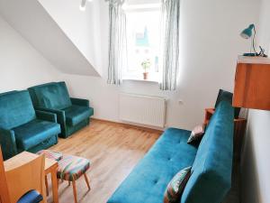 a living room with a blue couch and two chairs at Willa Tarma in Władysławowo