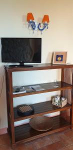 a entertainment center with a flat screen tv on a wall at Ascanio Appartamenti in Castiglione del Lago