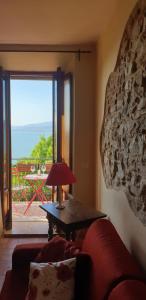 a living room with a red couch and a table with a lamp at Ascanio Appartamenti in Castiglione del Lago