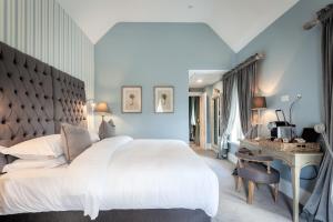 a bedroom with a large white bed and a desk at The Rooms at Cunningham's in Kildare