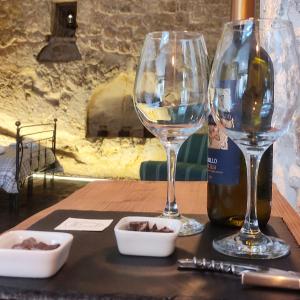 a table with two wine glasses and a bottle of wine at la Postierla in Modica
