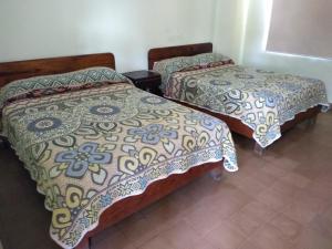 dos camas sentadas una al lado de la otra en una habitación en Hotel Colimense, en Acapulco