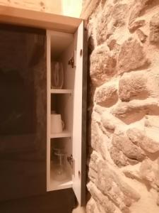 a white cabinet next to a stone wall at Studio au centre ville de Carcassonne in Carcassonne