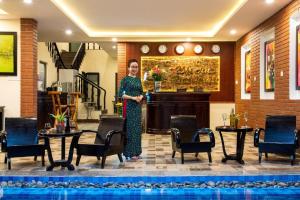 a woman standing in the lobby of a hotel at Hoi An Riverland Villa - Hoi An Center in Hoi An