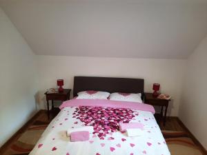 a bedroom with a bed covered in pink confetti at Village House Aleksic in Pošćenje