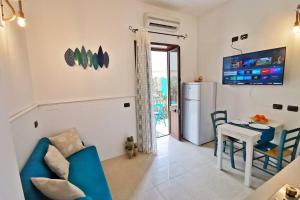 een woonkamer met een blauwe bank en een tafel bij Loft Palm Beach - 100 metri dalla spiaggia di sabbia bianca e dal mare in Fontane Bianche