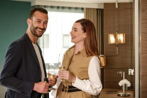 a man and a woman holding glasses of wine at Hyatt Regency Malta in St. Julianʼs