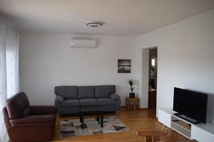 uma sala de estar com um sofá e uma televisão em Dodo em Kaštela