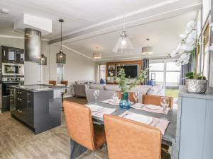 uma cozinha e sala de estar com mesa e cadeiras em Fairway View 24 em Burnham-on-Sea