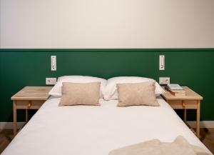 a bedroom with a large white bed with a green wall at Líbere Bilbao La Vieja in Bilbao
