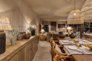 a dining room with tables and chairs and a kitchen at Terra Rosa Country House & Vineyards in Ponte de Lima