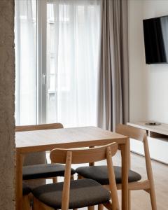 drewniany stół i krzesła w pokoju z oknem w obiekcie Apartamentos Líbere Bilbao La Vieja w mieście Bilbao