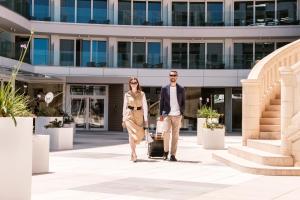 a man and woman walking in front of a building at Hyatt Regency Malta in St. Julianʼs