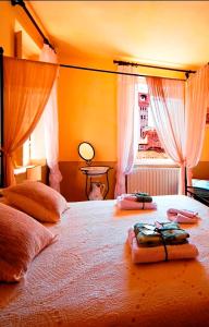 a bedroom with a large bed with towels on it at Bed and Breakfast Evelina in Lucca