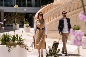 a man and a woman walking down a sidewalk with a suitcase at Hyatt Regency Malta in St. Julianʼs