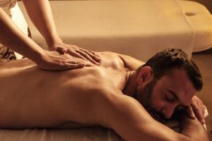 a man laying on a bed getting a massage at Hyatt Regency Malta in St. Julianʼs