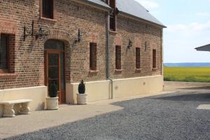 un edificio de ladrillo con una maceta delante de él en La Grange de Boulaines, en Méru