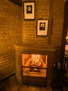 a brick fireplace with a fire in it at Hotel Fazenda Minha Glória in Bom Jardim