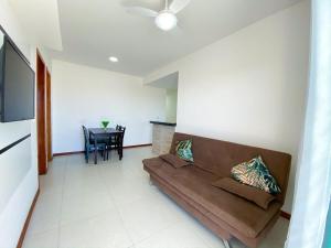 ein Wohnzimmer mit einem Sofa und einem Tisch in der Unterkunft Varandão Incrível E Um Deslumbrante Pôr do Sol 304 in Cabo Frio
