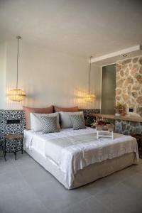 een slaapkamer met een groot wit bed en een tafel bij Delight Apartments suites in Stelida
