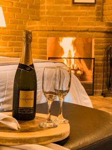 邦雅爾丁的住宿－Hotel Fazenda Minha Glória，一瓶香槟和一张桌子上的两杯酒