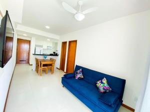 a living room with a blue couch and a table at Arejado com Localização Estratégica e Varandão - 203 in Cabo Frio