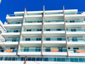 un alto edificio bianco con balconi di Férias em Família, Aconchego e Privacidade 209 a Cabo Frio