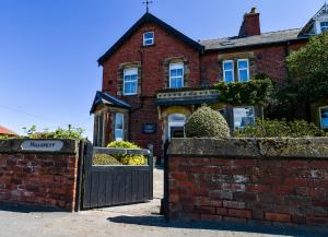 een stenen huis met een poort en een stenen muur bij Hillcrest Whitby in Whitby