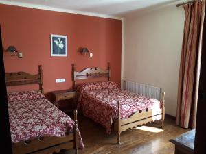 two beds in a room with red walls at Hostal Ayestaran I in Lekunberri